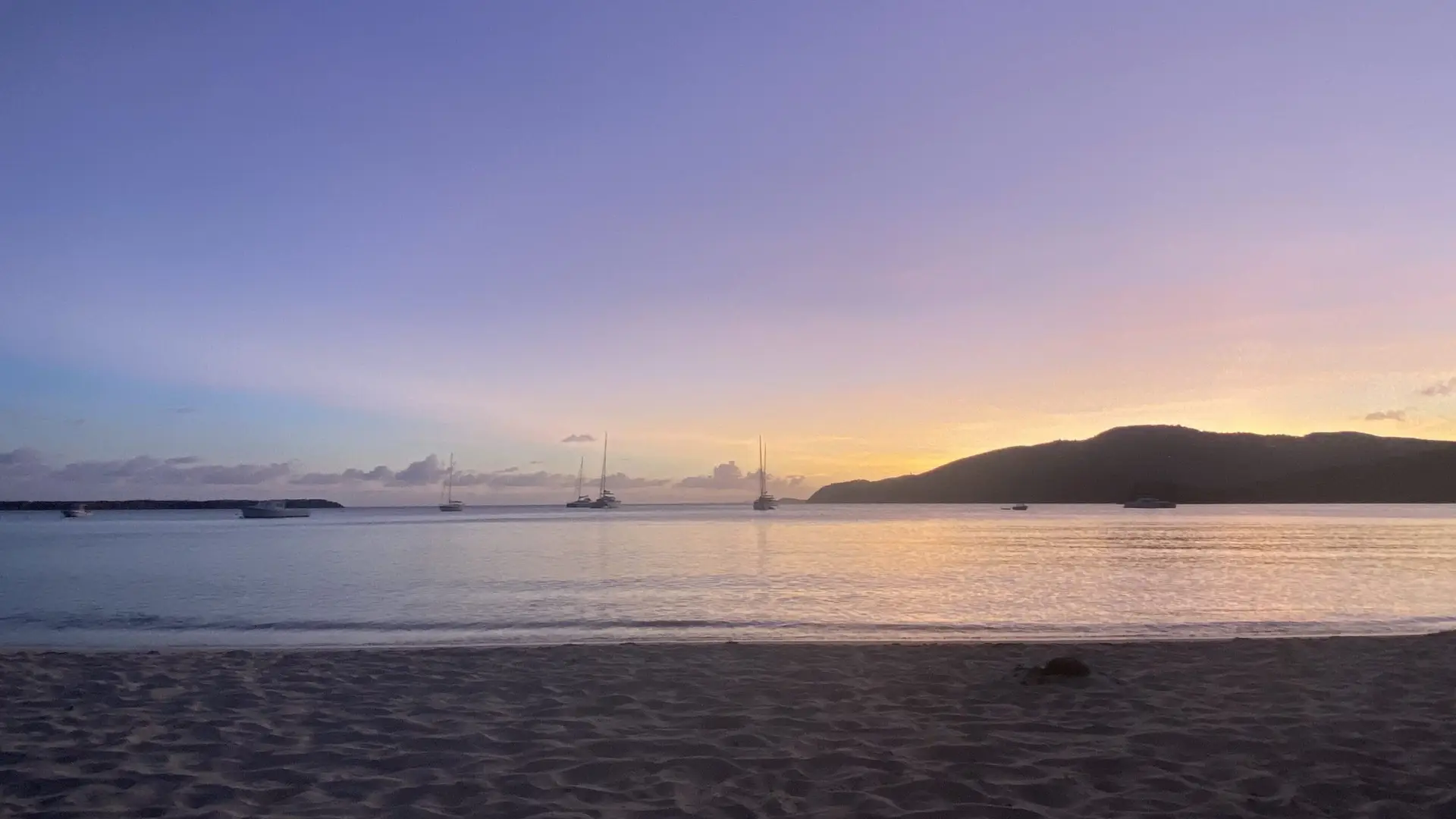 Colorful sunset over one of the serene St. Thomas beaches with vibrant hues in the sky and calm waters.